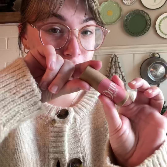 Emma is showing how to apply Ditto Balms solid perfume to pulse points